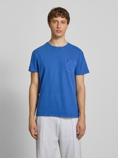 Männermodel trägt T-Shirt aus Baumwoll-Leinen-Mix mit Brusttasche von Superdry in Blau, Regular-Fit, Rundhalsausschnitt, Rückenlänge 66 cm, Ganzkörperansicht von vorne.
