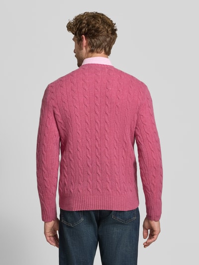 Männermodel trägt Regular Fit Pullover aus Woll-Kaschmir-Mix von Polo Ralph Lauren in Rosa mit Zopfmuster, Ganzkörperansicht Rückansicht. Herren Pullover von Polo Ralph Lauren