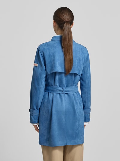 Frauenmodel trägt Trenchcoat mit Bindegürtel Modell 'CORDELIA' von Frieda & Freddies in Blau, Material-Mix mit Stretch, Rückenansicht, ganzkörper.