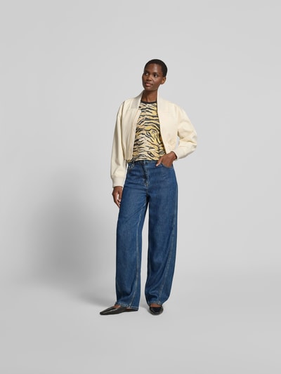 Frauenmodel trägt Regular Fit Bomberjacke mit Stehkragen von Self-Portrait aus reiner Baumwolle in Creme, kombiniert mit Jeans; Ganzkörperansicht von vorne.