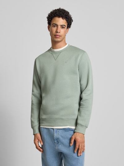 Męski model nosi bluzę z mieszanki bawełny Sweatshirt aus Baumwoll-Mix Modell 'Premium core' od G-Star Raw, prosty krój, okrągły dekolt, wyhaftowane logo, elastyczne wykończenia, długość tyłu 66 cm, długość rękawa 67 cm, widok całej sylwetki z przodu.