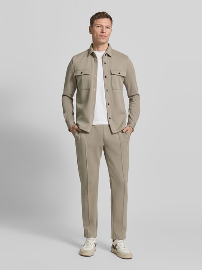 Männermodel trägt Hemdjacke mit Druckknopfleiste van MCNEAL in beige, regular fit, borstzakken, volledige voorkant. Ganzkörperansicht von vorne.
