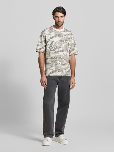 Männermodel trägt Regular Fit T-Shirt aus reiner Baumwolle Modell 'TE_WILDNATURE' von BOSS Orange mit abstraktem Allover-Muster in Beige und Grau, kurzarm und Rundhals, Ganzkörperansicht von vorne.