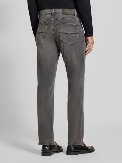 Männermodel trägt Straight Fit Jeans aus elastischem Baumwoll-Mix Modell 'Lyon' von Pierre Cardin im Used-Look, Ganzkörperansicht Rückansicht. 5-Pocket-Design, mittleres Grau, sichtbare Gürtelschlaufen, strukturierte Oberfläche, Knopf- und Reißverschluss.
