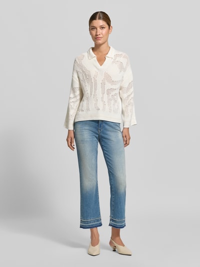 Frauenmodel trägt Flared Fit Jeans aus Baumwoll-Mix in verkürzter Passform von Marc Cain, hellblaue Waschung, 5-Pocket-Design, Ganzkörperansicht von vorne.