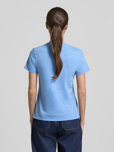 Frauenmodel trägt T-Shirt mit Rundhalsausschnitt und Motiv-Stitching von JOOP! in Hellblau aus reiner Baumwolle, gerader Schnitt, Rückenlänge bei Größe 36: 57 cm, Ganzkörperansicht Rückansicht.