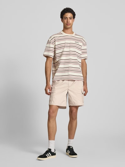 Männermodel trägt Regular Fit Cargoshorts mit Baumwoll-Anteil von Only & Sons, efekt: jednolity kolor, krój regular fit, tunel, ściągacz, kieszeń z tyłu, kieszeń cargo, wykończenie materiału: popelina, materiał: mieszanka bawełny, ganzkörperansicht von vorne.