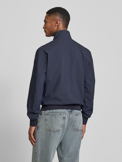 Männermodel trägt marineblaue Jacke mit Label-Patches Modell 'Anson' von Blauer Usa, gerader Schnitt, Ganzkörperansicht Rückansicht.