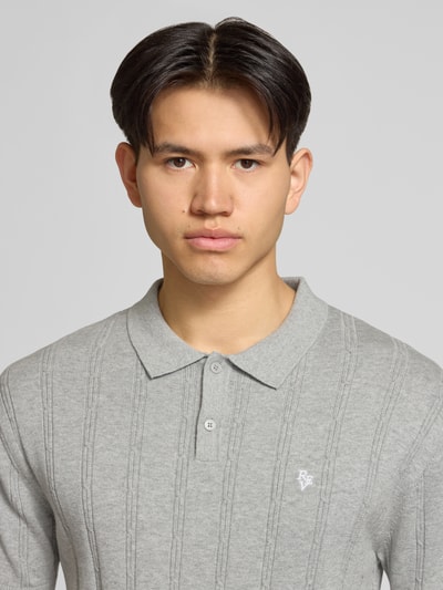 Männermodel trägt Slim Fit Strick-Poloshirt mit Label-Stitching von REVIEW in Grau, Zopfmuster, Reine Baumwolle, Nahaufnahme Oberkörper.