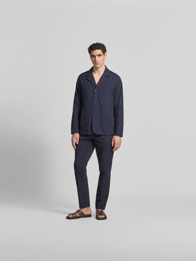 Männermodel trägt Straight Fit stoffen broek uit puur katoen van Officine Générale, donkerblauw, met band, haakjes- en ritssluiting, stolpplooi, steek- en achterzakken, binnenbeenlengte maat 50: 79 cm, bandwijdte maat 50: 45 cm, ganzkörperansicht van voren.
