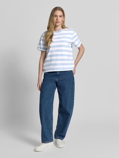 Kobiece model nosi damski t-shirt Boxy Fit T-Shirt aus reiner Baumwolle Modell 'ESSENTIAL' od Selected Femme, efekt: wzór w paski, naszywka z logo, okrągły dekolt, krótki rękaw, wykończenie: heavy jersey, materiał: czysta bawełna, całkowity widok z przodu.
