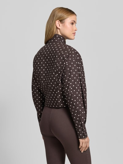 Frauenmodel trägt Kurze voluminöse Bluse - curated by Mary Braun von Style Icon Collection in Dunkelbraun mit weißen Punkten, reine Baumwolle, Regular Fit, Stehkragen, Rückenansicht Ganzkörperaufnahme.