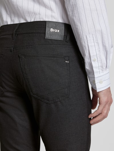 Männermodel trägt Hose mit Eingrifftaschen Modell 'Chuck' von BRAX in Schwarz, Material-Mix mit Viskose-Anteil, Nahaufnahme Rückansicht.