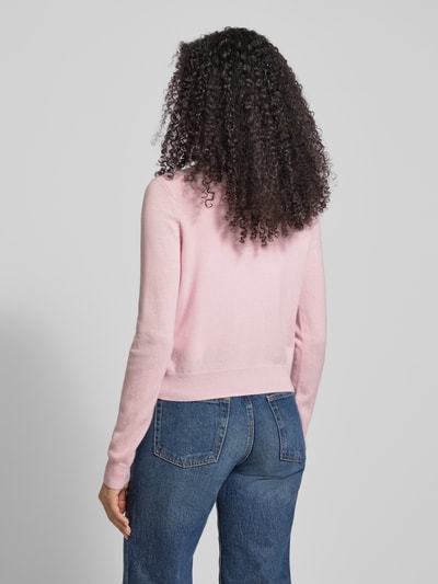 Frauenmodel trägt Slim Fit Strickjacke aus Woll-Kaschmir-Mix Modell 'NEBBIA' von Weekend Max Mara in Rosa, feine Stricktextur, Ganzkörperansicht Rückansicht