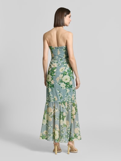 Frauenmodel trägt Regular Fit Maxikleid mit floralem Allover-Print von Mascara, Taillierte Passform, Unterrock, Nahtreißverschluss, Schulterfrei, Farbspiel aus Grün und Creme, transparente Texturen, Rückenlänge bei Größe 36: 15 cm, Brustweite: 35 cm, Ganzkörperansicht Rückansicht.