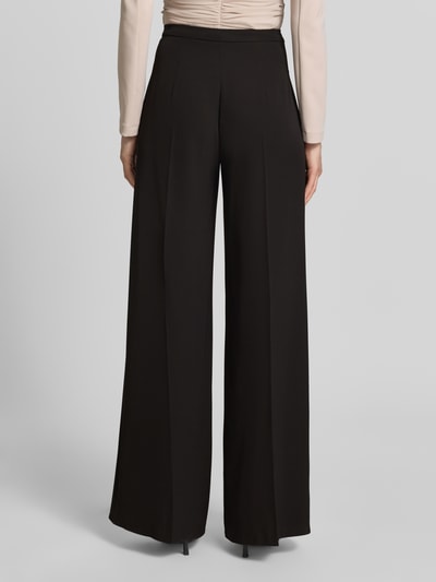 Frauenmodel trägt schwarze Stoffhose mit Bügelfalte von Rinascimento, Material-Mix mit Stretch, Wide Leg, Ganzkörperansicht Rückansicht.