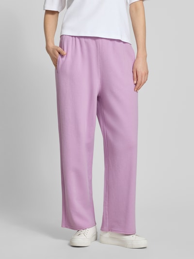 Vrouwenmodel draagt sweatpants met elastische band model 'ATUBAY' van American Vintage, mix van katoen en elastaan, wide leg, tunnelkoord, dames sweatpants, lila kleur, binnenbeenlengte maat M 70 cm, detailopname van het onderlichaam.
