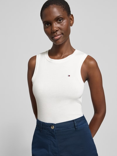 Vrouwenmodel draagt Slim Fit Tank Top uit puur katoen model 'SLIM CODY' van Tommy Hilfiger, look: effen, gestikt logo, ronde hals, brede bandjes, voorkant bovenlichaam close-up.