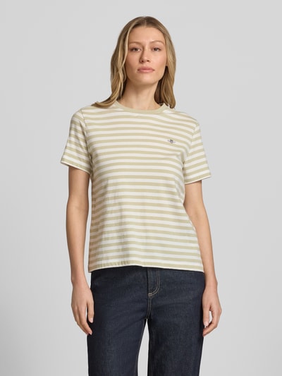 Frauenmodel trägt T-Shirt mit Rundhalsausschnitt und Label-Stitching von Gant, Damen T-Shirt aus Reine Baumwolle, Regular-Fit, beige und weiß gestreift, Rückenlänge bei Größe S 56 cm, Ganzkörperansicht von vorne.