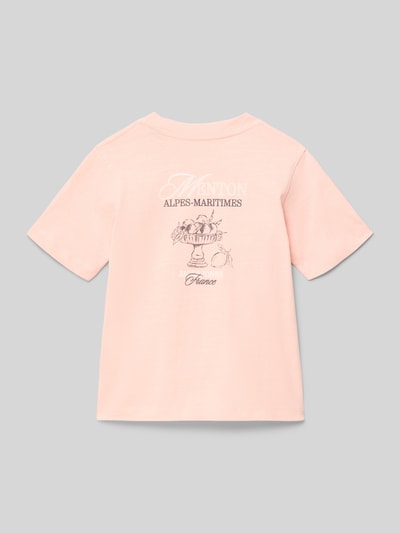 Mädchen trägt Kinder T-Shirt von Jack & Jones Modell 'CASSIS' in Rosa mit Statement-Print und Label-Detail aus Reine Baumwolle, Regular-Fit, Rundhalsausschnitt, Rückenlänge bei Größe 140: 50 cm, Ganzkörperansicht Rückansicht.