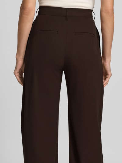 Vrouwenmodel draagt Barrel Fit stoffen broek met viscosemix van DRYKORN in donkerbruin met strookzakken, bandwijdte maat 27/34: 37 cm, binnenbeenlengte 80 cm, materiaalmix, geheel achteraanzicht.