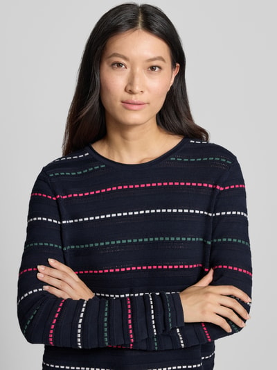 Frauenmodel trägt Strickpullover mit Struktur-Muster von Christian Berg Woman in Dunkelblau mit Streifen in Weiß, Grün und Rot, reine Baumwolle, gerader Schnitt, Rundhalsausschnitt, Nahaufnahme Oberkörper.