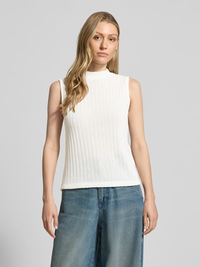 Kobiece modelka nosi top z dzianiny w kolorze białym o efekcie prążkowania, model 'Usodie' od Someday, mieszanka materiałów z dodatkiem wiskozy, krój regular fit, stójka, zdjęcie całej sylwetki z przodu.