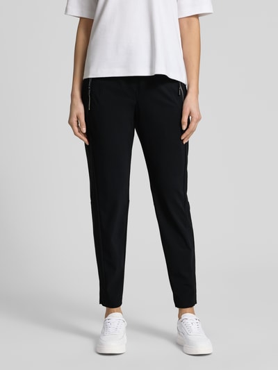 Frauenmodel trägt Stoffhose in 7/8-Länge mit Stretch-Anteil Modell 'NATINA' von Raffaello Rossi aus Elastischer-Material-Mix in Schwarz mit Reißverschlusstaschen, körpernahe Passform, elastischer Bund mit Gürtelschlaufen, Ganzkörperansicht von vorne.