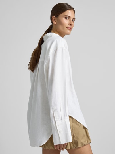 Modelka prezentuje Regular Fit Bluse aus Leinen-Baumwoll-Mix od Gina Tricot, mieszanka lnu i bawełny, krój regular fit, kołnierzyk koszulowy, listwa guzikowa, długość tyłu w rozmiarze S 74 cm, długość rękawów 60 cm, jasna faktura, prosty krój, widoczne guziki, widok całej sylwetki z tyłu.
