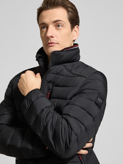 Männermodel trägt Regular Fit Steppjacke mit Stehkragen von Tom Tailor, Optik: Unifarben, Kontrastdetails, Nahaufnahme Oberkörper.