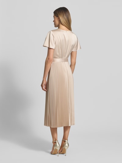 Frauenmodel trägt Midikleid mit Plisseefalten und V-Ausschnitt von comma in Beige, Material-Mix mit Stretch, tailliert, Rückansicht Ganzkörperansicht.