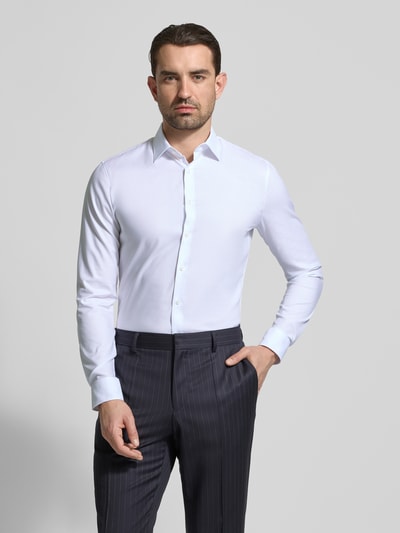 Männermodel trägt Super Slim Fit Business-Hemd mit Kentkragen und Strukturmuster von OLYMP, Baumwoll-Elasthan-Mix, Ganzkörperansicht von vorne. Rückenlänge 80 cm, Schulterbreite 44 cm, Ärmellänge 66 cm, Größe 40, feine Struktur, klassisch weiß.