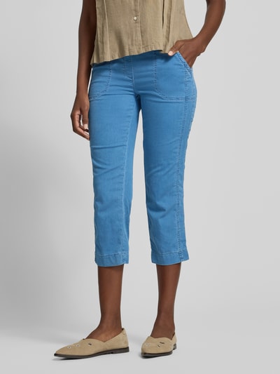 Frauenmodel trägt Jogpants mit elastischem Bund Modell 'Sue' von TONI aus Baumwoll-Mix mit Stretch-Anteil, leuchtend blaue Farbe, 3/4-Länge, seitliche Eingrifftaschen, Gesäßtaschen, glatte Textur, Ganzkörperansicht von vorne. Innenbeinlänge bei Größe 36: 60 cm, Bundweite: 37 cm.