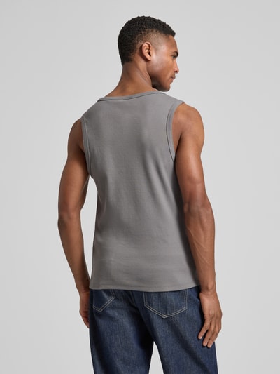 Männermodel trägt Slim Fit Tank Top aus Baumwoll-Mix Modell 'DAPOTA' von HUGO in Grau, Feinrippstruktur, unifarben, Ganzkörperansicht Rückansicht.