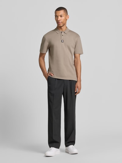 Männermodel trägt Regular Fit Poloshirt aus reiner Baumwolle Modell 'DEABONO' von HUGO in Optik: Unifarben mit Logo-Patch, Ganzkörperansicht von vorne.