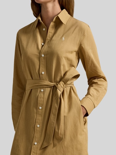 Frauenmodel trägt Hemdblusenkleid aus Baumwoll-Leinen-Mix von Polo Ralph Lauren in Beige mit tailliertem Schnitt, Taillengürtel, Hemdblusenkragen, Knopfleiste und Label-Stitching, Nahaufnahme Oberkörper.