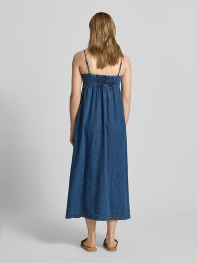 Frauenmodel trägt Maxi Freizeitkleid aus reiner Baumwolle von Tommy Jeans in Denim-Optik mit Empire-Passform, Ganzkörperansicht Rückansicht.