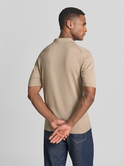 Męski model nosi Slim Fit Poloshirt aus Lyocell-Baumwoll-Mix od OLYMP Level Five, mieszanka lyocellu i bawełny, krój slim fit, kołnierzyk polo, krótki rękaw, długość tyłu w rozmiarze M: 68 cm, jednolity beżowy kolor, struktura gładka, zdjęcie całej sylwetki z tyłu.