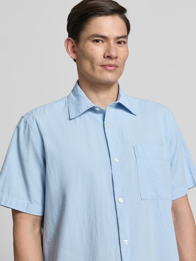 Männermodel trägt Relaxed Fit Freizeithemd aus reiner Baumwolle Modell 'STUART' von SELECTED HOMME, Optik:Allover-Muster, gestreift, Kentkragen, durchgehende Knopfleiste, Kurzarm, Brusttasche, Seersucker-Struktur, Reine Baumwolle, Nahaufnahme Oberkörper