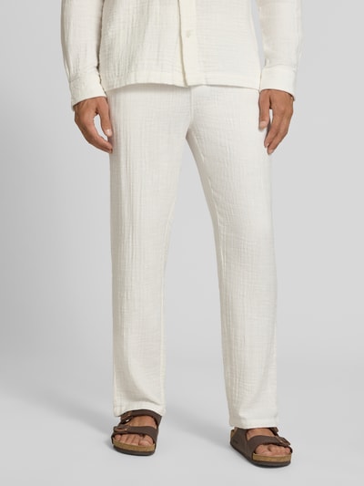 Männermodel trägt Straight Fit Sweatpants in Musselin-Optik von Lindbergh aus Reine Baumwolle, helle Farbe, strukturierte Oberfläche, Ganzkörperansicht von vorne. Bundweite Größe M 41 cm, Innenbeinlänge 81 cm, elastischer Bund mit Tunnelzug.