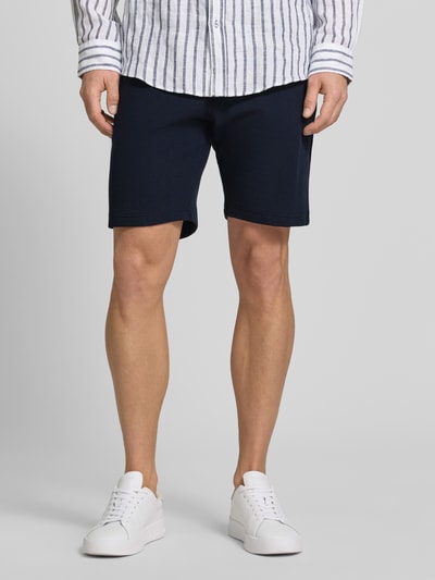 Männermodel trägt Shorts aus Baumwolle mit Strukturmuster von Christian Berg Men in Dunkelblau, Regular-Fit, elastischer Bund, Nahaufnahme Unterkörper.