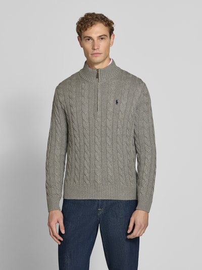 Männermodel trägt Relaxed Fit Troyer aus reiner Baumwolle von Polo Ralph Lauren in Hellgrau mit Zopfmuster, Ganzkörperansicht von vorne.