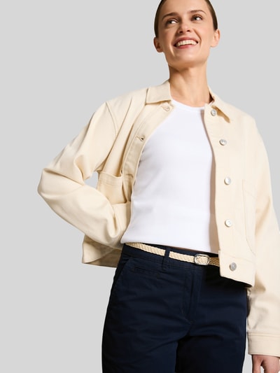 Kobiece modelka nosi Slim Fit Chino aus Baumwoll-Mix von Tom Tailor, efekt: jednolity kolor, krój slim fit, szlufki na pasek, szwy w kontrastowym kolorze, zapięcie na guzik i ukryty zamek błyskawiczny, pasek damski, zakończenie nogawek: brzeg, wpuszczane kieszenie, kieszenie z tyłu, materiał: mieszanka bawełny, kolor granatowy, tekstura gładka; z przodu, zbliżenie na górną część ciała