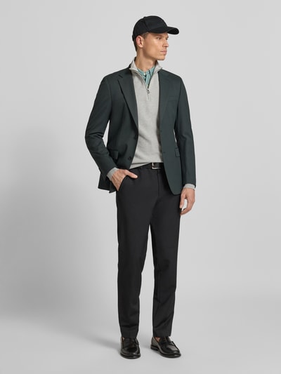 Mężczyzna-model nosi Sweter z dzianiny z wyhaftowanym logo od Polo Ralph Lauren z bawełny, krój regular fit, prążkowane wykończenia, stójka, krótki zamek błyskawiczny; długość tyłu 70 cm, długość rękawa 68 cm; kolory stonowane, tekstura gładka, widok całej sylwetki z przodu.