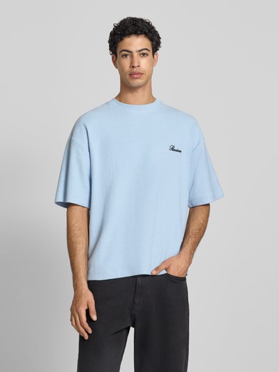 Männermodel trägt T-Shirt mit Rundhalsausschnitt und Label-Stitching von REVIEW, Relaxed-Fit, Baumwoll-Mix, hellblau, Ganzkörperansicht von vorne. Rückenlänge bei Größe M: 64 cm.