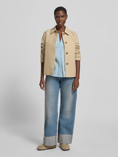 Frauenmodel trägt Regular Fit Bluse mit V-Ausschnitt Modell 'Ane' von FREE/QUENT in hellblau mit Lochstickerei, reine Baumwolle, kombiniert mit Jeans, Ganzkörperansicht von vorne.