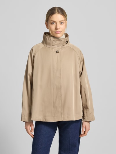 Modelka kobieca ma na sobie Jacke aus Baumwoll-Mix mit Stehkragen Modell 'JIL' od CINQUE w kolorze beżowym, prosta forma i gładka tekstura, długość tyłu 68 cm, szerokość ramion 35 cm, szerokość w rozmiarze 36: 65 cm, długość rękawa 71 cm, krój regular fit, widok całej sylwetki z przodu.