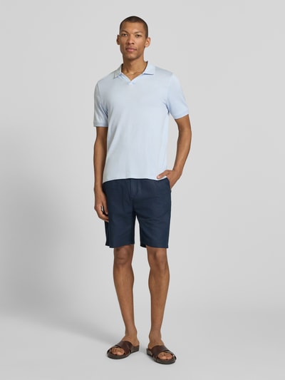 Mężczyzna-model nosi Slim Fit Poloshirt mit Logo-Detail Modell 'Boll' od CINQUE, jasnoniebieska bawełna, krótkie rękawy, kołnierzyk polo, elastyczne wykończenia rękawów, krój slim fit, Szerokość w rozmiarze M: 66 cm, pełny widok z przodu.