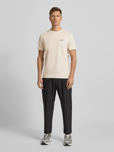 Męski model nosi Regular Fit T-Shirt aus Baumwoll-Mix od BOSS Green, jasny beż, gładka bawełna, nadruk logo, krótki rękaw, widok całej sylwetki z przodu.