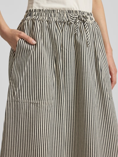 Frauenmodel trägt Maxirock mit Eingrifftaschen Modell 'Akane' von LOLLYS LAUNDRY aus Baumwoll-Mix, A-Linie, Nahaufnahme Oberkörper.